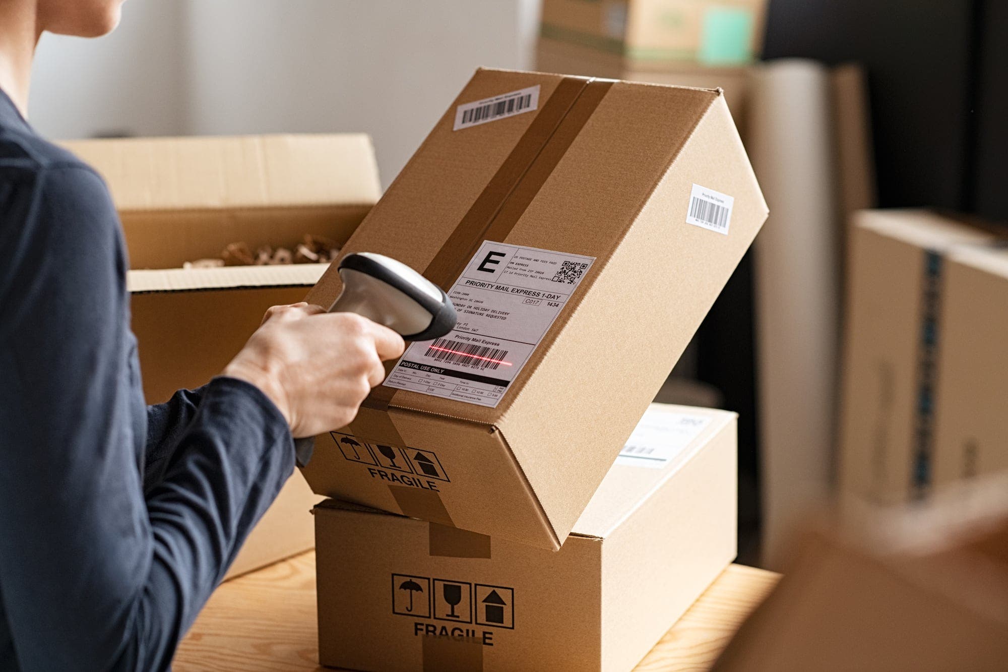 Hands of young woman scanning barcode on delivery parcel. Protecting sperm during transit