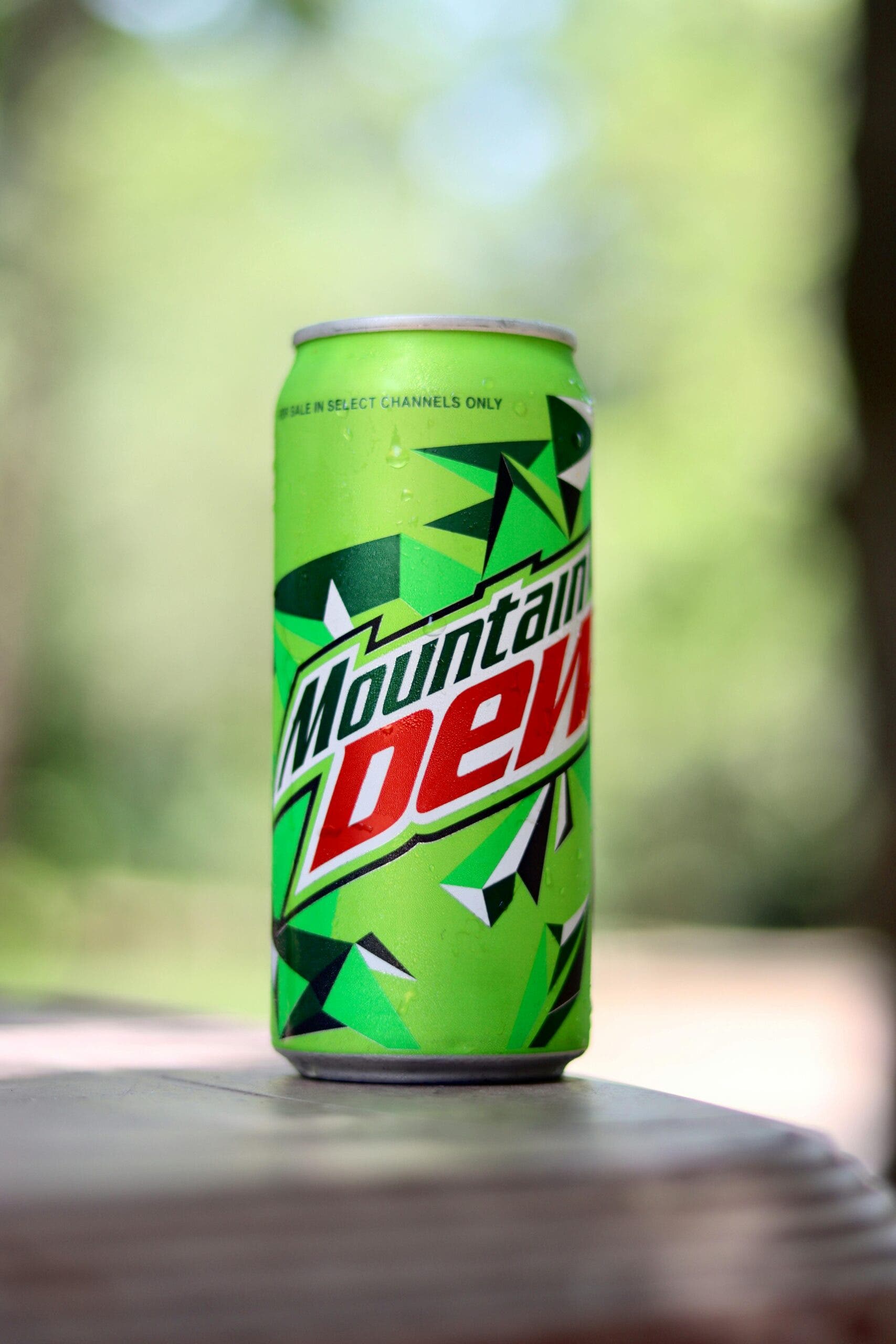 A chilled can of Mountain Dew soda placed outdoors, often linked to myths about lowering sperm count and its impact on male fertility.